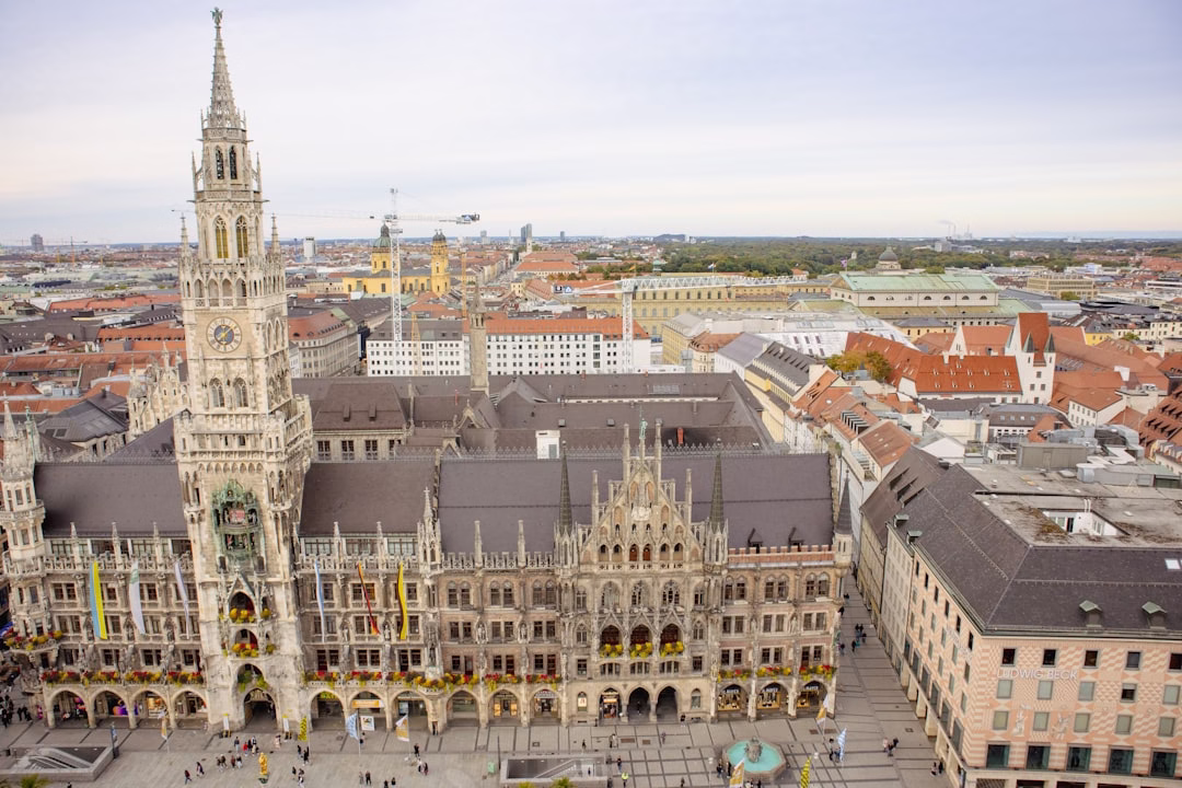 Vista aérea del Ayuntamiento de Múnich con su icónica torre gótica y la plaza Marienplatz llena de gente.